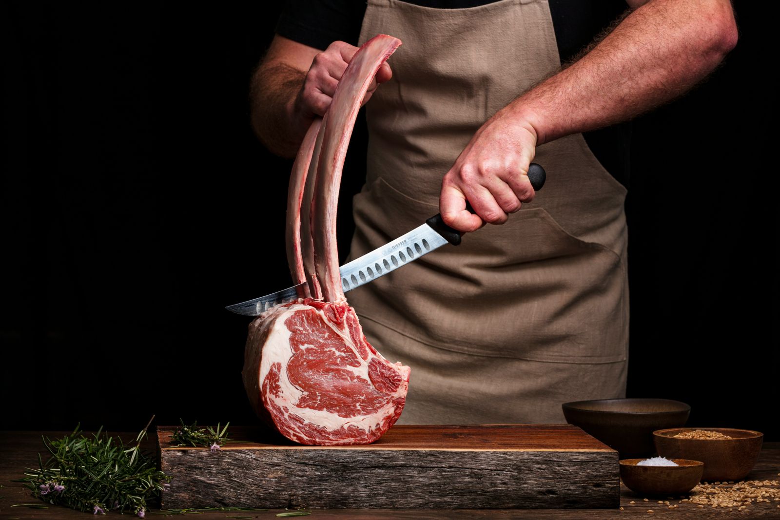 The butcher cutting steaks at the counter